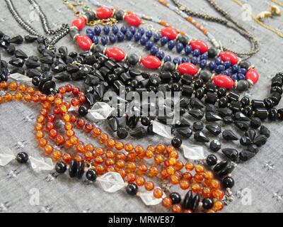A pile of necklaces and bracelets of assorted colors laid flat Stock Photo