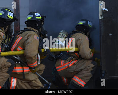 PORTSMOUTH, Va. (APRIL 14, 2017) Navy Sailors enter a burning building for Firefighter 1 live fire testing at Southside Regional Fire Academy. Stock Photo