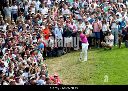 Northern Ireland's Rory McIlroy hits it out of the crowd on the first fairway during day four of the 2018 BMW PGA Championship at Wentworth Golf Club, Surrey. Stock Photo