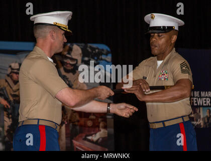 Sergeant Major Cortez L. Brown, right, receives the Noncommissioned Officer Sword from Col Jeffery C. Smitherman, commanding officer of 6th Marine Corps District (6MCD), during the 6MCD Relief and Appointment Ceremony at the base theater aboard Marine Corps Recruit Depot (MCRD) Parris Island, South Carolina, July 7, 2017. Sergeant Major Anthony N. Page was relieved by SgtMaj Cortez L. Brown after serving as the sergeant major of 6MCD for more than 3 years. (U.S. Marine Corps photo by LCpl. Jack A. Rigsby) Stock Photo