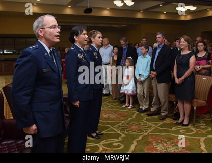 Maj. Gen. Bob LaBrutta, 2nd Air Force commander; Col. Michele Edmondson, outgoing 81st Training Wing commander, and Col. Debra Lovette, 81st TRW commander, sing the Air Force song during a change of command ceremony at the Bay Breeze Event Center June 2, 2017, on Keesler Air Force Base, Miss. The guidon ceremony is a symbol of command being exchanged from one commander to the next by the handing-off of a ceremonial guidon. (U.S. Air Force photo by Kemberly Groue) Stock Photo