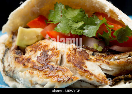 Fried mackerel fillet, Scomber scombrus, that was caught shore fishing from Chesil beach Dorset. Served in a pitta bread with a salsa of tomato, avoca Stock Photo