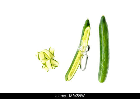 Whole cucumber and cucumber shavings on white background. Stock Photo