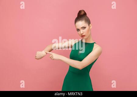 Look in my watch, time is gone! Hurry up. Expression emotion and feelings concept. Studio shot, isolated on pink background Stock Photo