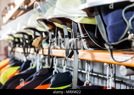 Helmets and uniforms in arsenal of fire fighters Stock Photo