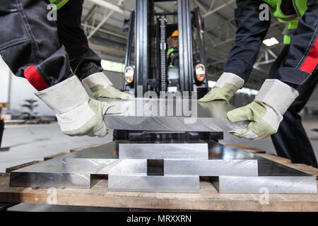 Workers taking aluminium billet at CNC machine shop Stock Photo