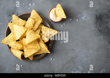 Nachos chips and cheese dip sauce. Tortilla corn nachos chips with  melted cheese, mexican snacks. Stock Photo