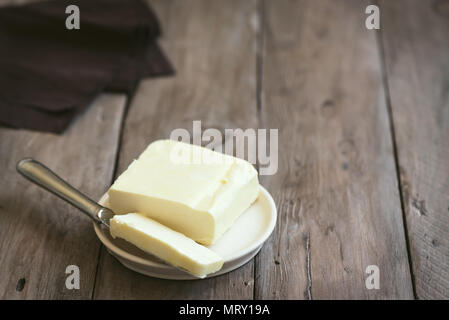 Butter on dark wooden background, copy space. Farm dairy product - butter. Stock Photo