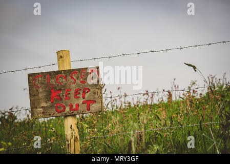 Hand made Keep out sign with barbed wire at field edge Stock Photo
