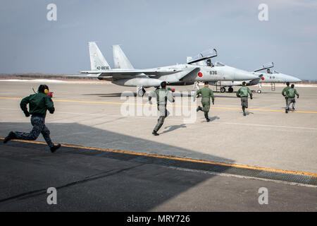 Koku-Jieitai pilots race to two Mitsubishi F-15J Eagles during a scramble demonstration as part of a 10-day U.S.-Japan Bilateral Career Training at Chitose Air Base, Japan, April 14, 2017. The scramble showcased the 2nd Air Wing’s response capability to outside threats as the installation responds to incursions into Japanese airspace every week. The F-15Js offer the Koku-Jieitai a twin-engine, all-weather air superiority fighter based on the U.S. Air Force’s McDonnell Douglas F-15 Eagle. Koku-Jieitai is the traditional term for Japan Air Self Defense Force used by the Japanese military. Stock Photo