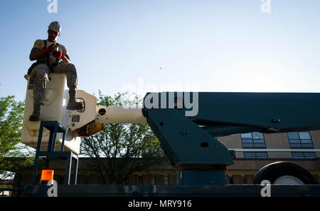 27th Special Operations Civil Engineer Squadron is a unit within Air Force Special Operations Command tasked with maintaining facilities at Cannon Air Force Base, New Mexico. The archival image documents an electrical systems specialist inspecting and replacing a lighting bulb on June 27, 2017, reflecting routine infrastructure maintenance and high work order volume for the installation. Stock Photo