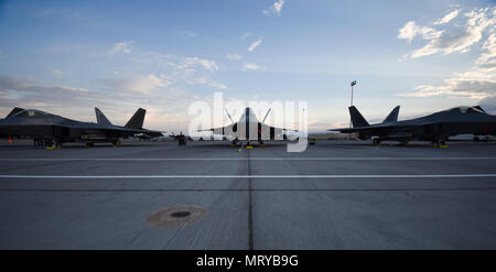 A group of F-22 Raptors from the 95th Fighter Squadron at Tyndall Air Force Base, Fla., sit on the flightline at Nellis Air Force Base, Nev., during Red Flag 17-3 July 10, 2017. Operational since December of 2005, the F-22 is designed to ensure America’s air dominance. (U.S. Air Force photo by Senior Airman Dustin Mullen/Released) Stock Photo