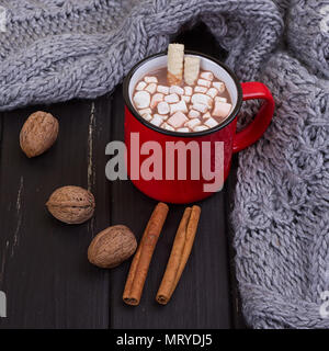 Hot cocoa with marshmallows with spices on the old wooden boards. Coffee, cocoa, cinnamon, nuts, cozy sweater. Autumn Still Life Stock Photo