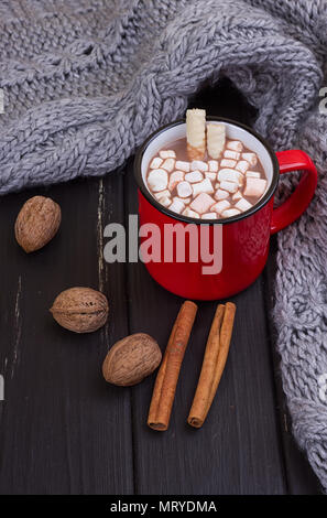 Hot cocoa with marshmallows with spices on the old wooden boards. Coffee, cocoa, cinnamon, nuts, cozy sweater. Autumn Still Life Stock Photo