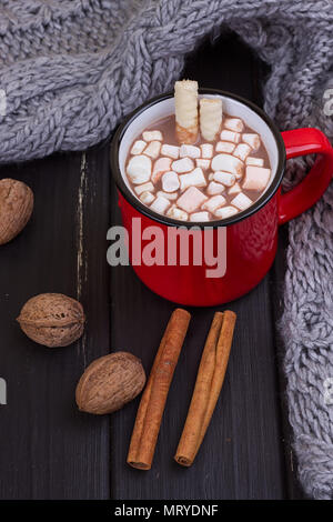 Hot cocoa with marshmallows with spices on the old wooden boards. Coffee, cocoa, cinnamon, nuts, cozy sweater. Autumn Still Life Stock Photo