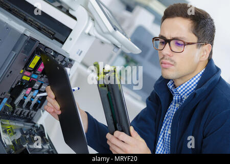 young engineer in the lab adjusting a 3d printers components Stock Photo
