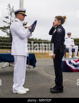 Naval Ocean Processing Facility Whidbey Island is a United States Navy command that conducts undersea data processing in support of fleet operations. On 13 July 2017 in Oak Harbor, Washington, the national ensign was presented during a change of command and retirement ceremony at the facility. The archival image documents the ceremonial flag presentation associated with the leadership transition. Stock Photo