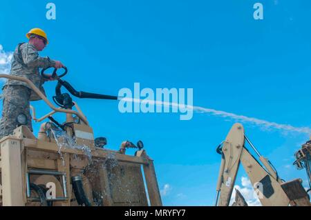 Cpl. George Hawkins, 733rd Engineering Company, Greenville, Tenn., uses a water cannon to clean construction equipment, a routine maintenance procedure, during Resolute Castle 17, at Cincu, Romania, June 15, 2017.  Hawkins, works as a store manager at Advance Auto Parts and traveled to Romania from his home in Clinton, Tenn. with fellow Army Engineers to construct a maneuver training range.  Once completed this facility will allow combat arms units from the U.S., Allied forces and partner nations, the opportunity to hone their warfighting skills and improve their lethality in the European thea Stock Photo