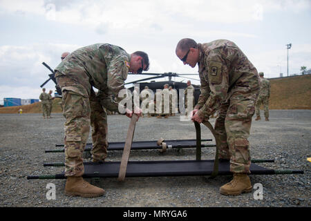 Sgt. Noah Hughes (left), medic with 421st Multifunctional Medical Battalion, 30th Medical Brigade, teaches Maj. David Farrington, soldier with 361st Civil Affairs Brigade, how to secure litter straps of a during training at Novo Selo Training Area, Bulgaria during Saber Guardian 17, July 17 (U.S. Army Reserve photo by Capt. Jeku Arce, 221st Public Affairs Detachment). Stock Photo