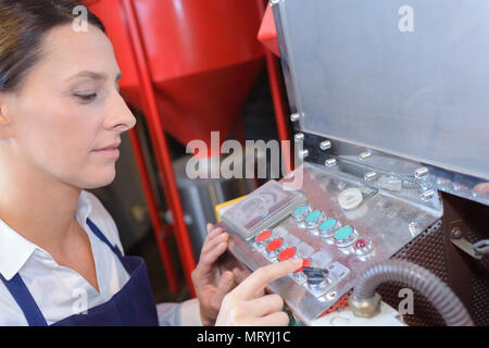 female worker using machine at the factory Stock Photo