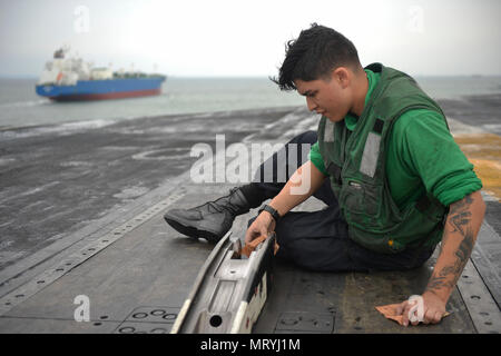 SINGAPORE STRAIT (July 6, 2017) U.S. Navy Aviation Boatswain's Mate (Equipment) Airman Miguel Torres Sandoval, a native of Long Beach, Calif., cleans a catapult system aboard the aircraft carrier USS Nimitz (CVN 68), July 6, 2017, in the Singapore Strait. Nimitz is currently on deployment in the U.S. 7th Fleet area of operations. The U.S. Navy has patrolled the Indo-Asia Pacific routinely for more than 70 years promoting regional peace and security. (U.S. Navy photo by Mass Communication Specialist 3rd Class Cole Schroeder) Stock Photo