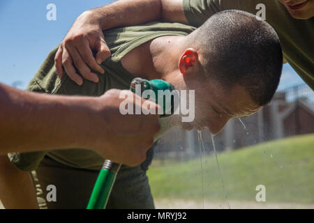 A student attached to Marine Corps Embassy Security Group is sprayed with water at the wash station during oleoresin capsicum (OC) spray training on Marine Corps Base Quantico, Va., July 7, 2017. Students are sprayed with OC as a part of their training to become Marine Security Guards. (U.S. Marine Corps photo by Lance Cpl. Yasmin D. Perez) Stock Photo
