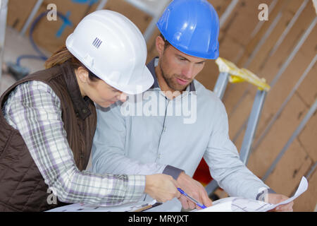 cheerful architects are consulting a blueprint Stock Photo