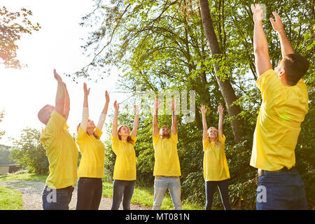 Young people in teambuilding workshop doing a stretching exercise in nature Stock Photo