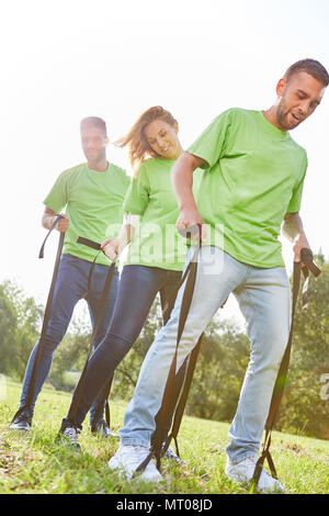 Three young people are doing an exercise for coordination at the teambuilding event Stock Photo