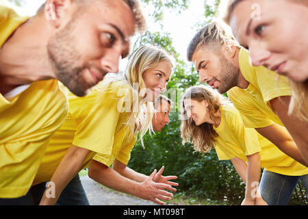 Young people are doing an exercise for teamwork at the teambuilding workshop Stock Photo