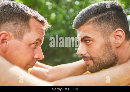 Two young men are doing an exercise for team development and looking at each other Stock Photo