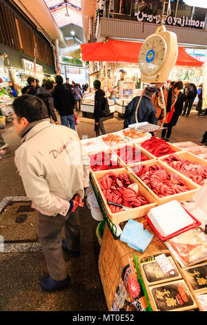 Indoor Omicho Ichiba, Omicho Market, est mid 18th century, largest fresh food market in Kanazawa, Japan. Red and bloodied octopus in boxes on stall. Stock Photo