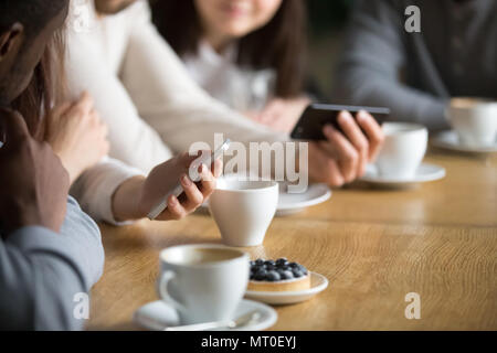 Diverse people using smartphones at cafe table, close up view Stock Photo