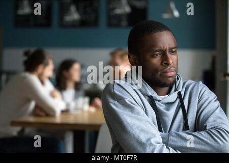 Frustrated african man suffers from racial discrimination alone  Stock Photo