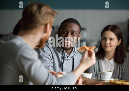 Happy african man laughing at friends joke hanging in pizzeria Stock Photo