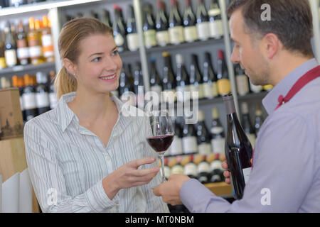 Vendor passing customer a glass of wine to try Stock Photo