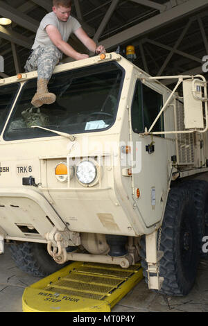 Indiana National Guard Spc. Joseph Long, from Madison, Indiana and a 1438th Transportation Company truck driver, installs a transmitter onto a tactical truck at the Fort Polk, Louisiana railhead, Tuesday, July 18, 2017. Long is one of more than 200 soldiers from the 38th Sustainment Brigade assisting with the 76th Infantry Brigade Combat Team’s rotation at the Joint Readiness Training Center. Photo by Master Sgt. Jeff Lowry, 38th Infantry Division Public Affairs Stock Photo