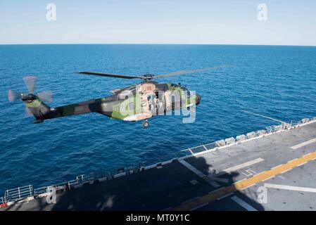 170719-N-NB544-055 CORAL SEA (July 19, 2017) A Royal Australian Navy MRH-90 Taipan helicopter takes off from the amphibious assault ship USS Bonhomme Richard (LHD 6) during Talisman Saber 17. Talisman Saber is a biennial U.S.-Australia bilateral exercise held off the coast of Australia meant to achieve interoperability and strengthen the U.S.-Australia alliance. (U.S. Navy photo by Mass Communication Specialist 2nd Class Kyle Carlstrom/Released) Stock Photo