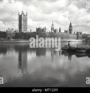 1950s, historical, view from the south of the river across the Thames, London, to the iconic buildings of the Palace of Westminster, meeting place of the UK Government. At the palace are the two Houses of  the UK Parliament, the House of Commons and the House of Lords.