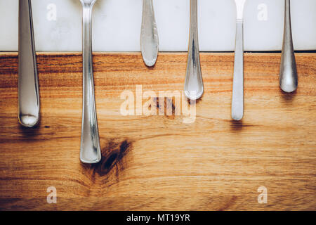 different spoons on stone marble wooden table background. Rustic vintage color toning. Stock Photo