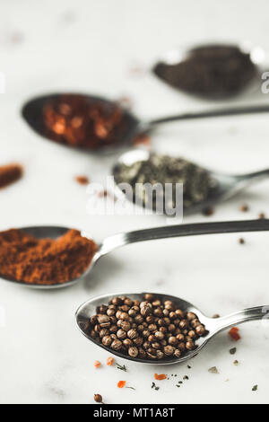 Spices in different spoons on stone marble table background. Rustic vintage color toning. Stock Photo