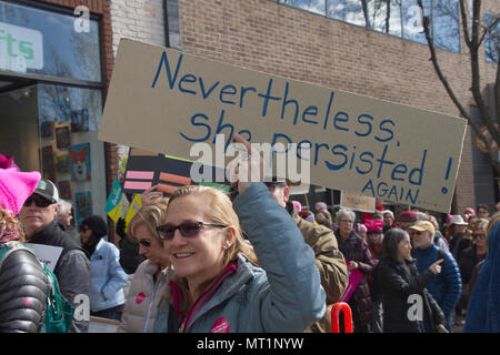 ASHEVILLE, NORTH CAROLINA, USA - JANUARY 20, 2018: Woman among a large crowd marching in the 2018 Women's March holds a political sign saying 'Neverth Stock Photo