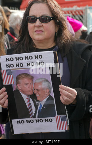 ASHEVILLE, NORTH CAROLINA, USA - JANUARY 20, 2018: Woman among a large crowd marching in the 2018 Women's March holds a political sign showing Donald  Stock Photo