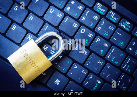 Golden padlock on computer laptop keyboard with Security word engraved. Concept of Internet security, data privacy, cybercrime prevention. Stock Photo