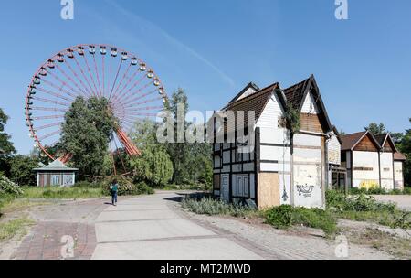 Berlin, Deutschland. 25th May, 2018. View of the rusting Ferris wheel in the former Spree Park in the Berlin Plaenterwald, in the foreground are dummies of houses. In GDR times, the park was a well-attended amusement park. Gruen Berlin GmbH will redesign the park. | usage worldwide Credit: dpa/Alamy Live News Stock Photo