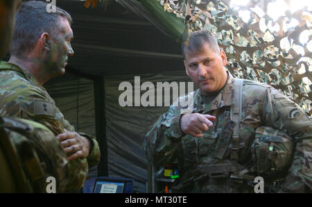 New York Army National Guard Brig. Gen. Joseph Biehler, the 42nd Infantry Division deputy commander converses with Lt. Col. James Matchett, the commander of the 1st Combat Service Support Battalion, Australian Army, at the brigade maintenance area at Shoalwater Bay, Queensland, Australia ,during Combined Exercise Talisman Saber, July 18. More than 700 New York Army National Guard Soldiers traveled to Australia where they spent three weeks training with Australian and New Zealand service members. (U.S. Army National Guard photo by Sgt. Alexander Rector) Stock Photo