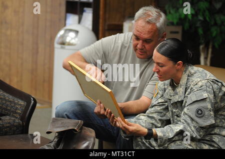 Sgt. Angela Myers, 311th ESC ammunition sergeant, looks over photos she's never seen with her Uncle Corey Rose. This is Myers first time meeting her uncle or any biological family. She was raised in foster care. Stock Photo