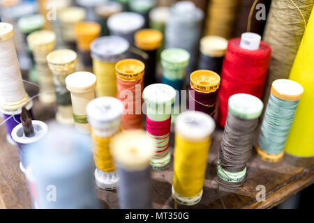 Colourful cotton bobbins and thread in a tailors shop in the UK Stock Photo