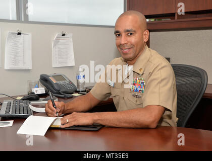 170725-N-UN340-010 SAN DIEGO (July 25, 2017)  Space and Naval Warfare Systems Command (SPAWAR) Command Master Chief Pablo Cintron prepares for a career development board for a SPAWAR Sailor on the systems command’s Old Town Complex.  Career development boards, which provide Sailors with the guidance necessary to make informed career decisions, are one of many leadership and mentoring responsibilities shouldered by the Navy’s Chief Petty Officer community.  (U.S. Navy photo by Rick Naystatt/Released) Stock Photo