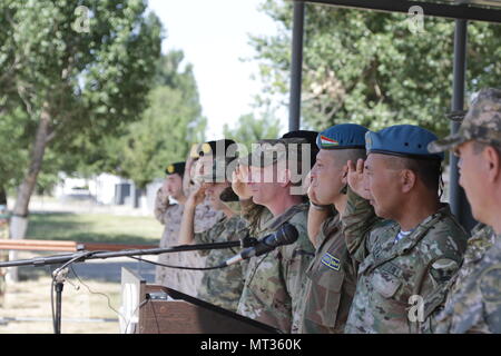 Maj. Gen. Murat Bektanov, the Kazakhstan Land Forces commander, and representatives from partner nations participating in Exercise Steppe Eagle 2017, salute soldiers as they march past during the opening ceremony, July 22, at the Illisky Training Center, at Almaty, Kazakhstan. Stock Photo